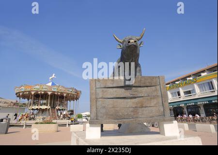 Statue eines Stiers und Karussells der Camargue, Les Saintes-Maries-de-la-Mer, Camargue, Bouches-du-Rhone, Provence-Alpes-Cote d'Azure, Südfrankreich, Frankreich Stockfoto