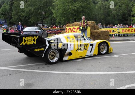 Ein gelber Porsche-Rennwagen neben Strohballen auf der Rennstrecke, Fahrer steht daneben, SOLITUDE REVIVAL 2011, Stuttgart, Baden-Württemberg Stockfoto