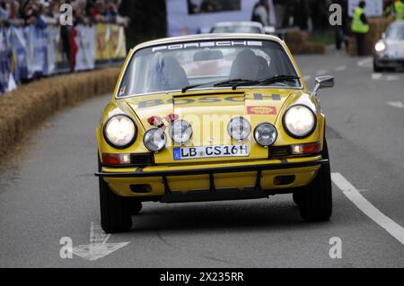 Ein klassischer gelber Porsche 911 auf einer Rallyespiste, flankiert von Zuschauern, SOLITUDE REVIVAL 2011, Stuttgart, Baden-Württemberg, Deutschland Stockfoto