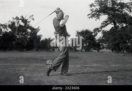 1951, historisch, auf einem flachen Golfplatz im Landesinneren, Seitenansicht eines Golfers, der einen Ball aus dem Abschlag schlägt, zeigt seine Zielposition mit rechtem Knie und rechtem Ellblow, der auf die Flugrichtung des Balls zeigt, England, Großbritannien. Stockfoto