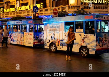 Abendlicher Spaziergang durch Shanghai zu den Sehenswürdigkeiten, Shanghai, beleuchteter Stadtbus bei Nacht mit einer Person im Vordergrund, Shanghai, Volksrepublik Stockfoto