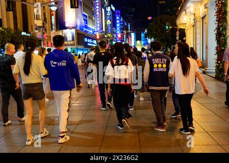 Abendlicher Spaziergang durch Shanghai zu den Sehenswürdigkeiten, Shanghai, Menschenmenge, die nachts durch eine mit Neonschildern beleuchtete Stadtstraße spaziert Stockfoto