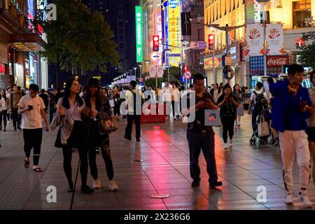 Abendlicher Spaziergang durch Shanghai zu den Sehenswürdigkeiten, Shanghai, Menschen schlendern durch eine beleuchtete Straße bei Nacht, umgeben von urbaner Landschaft, Shanghai Stockfoto