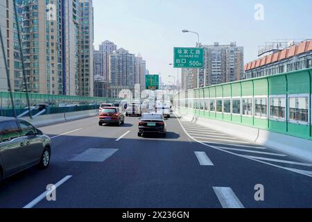 Verkehr in Shanghai, Shanghai Shi, Fahrzeuge auf einer städtischen Straße mit Hochhäusern und Verkehrsschildern, Shanghai, Volksrepublik China Stockfoto