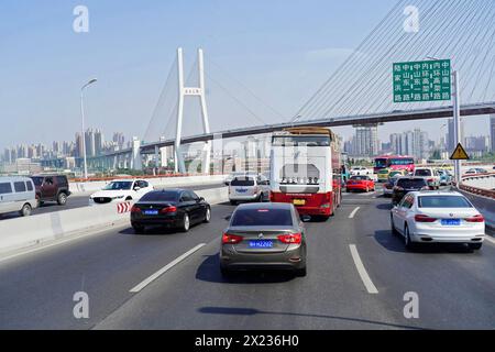 Verkehr in Shanghai, Shanghai Shi, starker Verkehr auf einer Autobahn mit einer großen Brücke im Hintergrund, Shanghai, Volksrepublik China Stockfoto