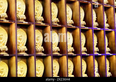 Jade Buddha Tempel, Shanghai, Reihen von kleinen goldenen Buddha Figuren auf Regalen als Wanddekoration, Shanghai, China Stockfoto