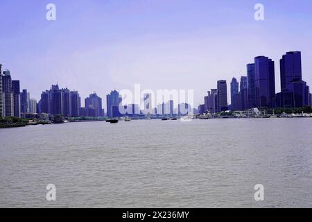 Machen Sie einen Spaziergang durch Shanghai zu den Sehenswürdigkeiten, Shanghai, China, Asien, Blick auf eine ruhige Weite des Wassers mit der Skyline von Shanghai im Hintergrund Stockfoto