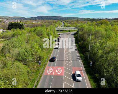 Pontypridd, Wales - 18. April 2024: Drohnenansicht des Verkehrs auf der Umgehungsstraße von Church Village mit Straßenmarkierungen, die den Beginn einer 20-km-Zone zeigen Stockfoto