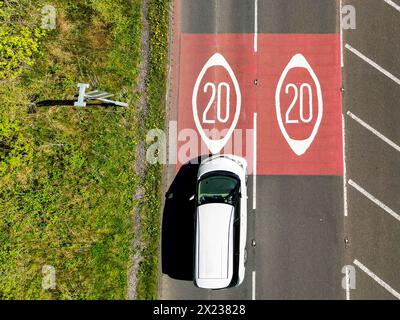 Pontypridd, Wales - 18. April 2024: Drohnenansicht eines Autos auf der Umgehungsstraße von Church Village, die sich Straßenmarkierungen nähert, die den Beginn einer 20-km-Zone zeigen Stockfoto