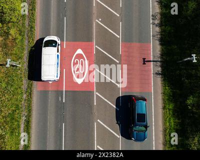 Pontypridd, Wales - 18. April 2024: Drohnenansicht der Autos auf der Umgehungsstraße von Church Village, vorbei an Straßenmarkierungen, die den Beginn einer 20-km-Zone zeigen Stockfoto