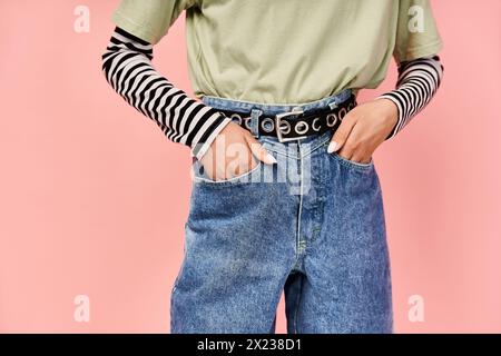 Ein stylisches, gut aussehendes Teenager-Mädchen posiert aktiv in einem leuchtend grünen Hemd und einer Jeans. Stockfoto