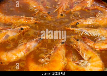 Erleben Sie kulinarische Harmonie, während die goldfrittierten Garnelen sich dem lebhaften Gemisch der Aromen in der traditionellen spanischen Paella anschließen und jeden Bissen mit s bereichern Stockfoto