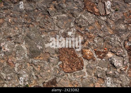 Steinstruktur einer Mauer in Montenegro. Eine alte Mauer aus braunen Steinen. Hintergrund. Vorlage. Für Design. Horizontal. Stockfoto