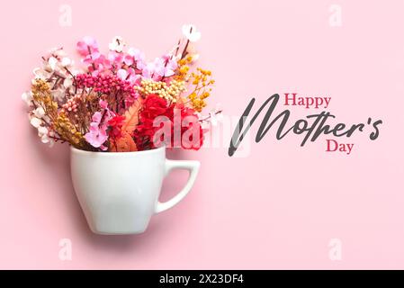 Alles Gute zum Muttertag. Weiße Tasse Kaffee mit verschiedenen Blumen und der Text Happy Mothers Day auf rosa Hintergrund Stockfoto
