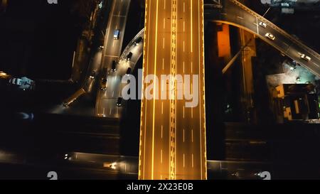 Nahverkehrsstraße mit Autos, Lastwagen fahren nachts von oben nach unten aus der Luft. Philippinen Hauptstadt Manila Autobahn mit Transport Fahrt bei Neonlicht. Erstaunlich beleuchtete Stadtlandschaft Drohne aufgenommen Stockfoto