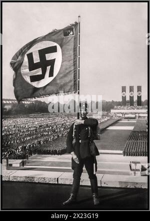 Waffen SS Hakenkreuz Fahnenträger, posiert für ein NS-Parteipropagandandabild in der Luitpold Arena in Nürnberg für eine Nazi-Parteikundgebung 1933 Nazi-Deutschland Stockfoto