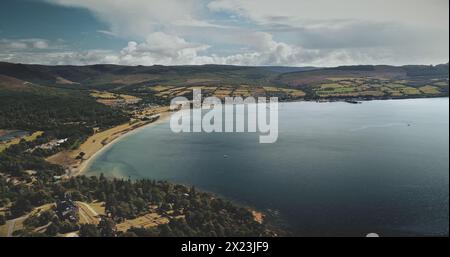 Schottlands Ozean, Brodick Harbour aus der Vogelperspektive: Fähre, Schiffe, Boote. Majestätische Meereslandschaft des Piers am Firth-of-Clyde Golf. Naturlandschaft mit weiten Wäldern, Parks und Wiesen Aufnahme Stockfoto