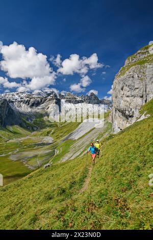 Mann und Frau Wandern mit Blick auf Tschingelhörner und unteren Segnesboden, tektonische Arena Sardona, Glarner Hauptschub, UNESCO-Weltnaturerbe G Stockfoto