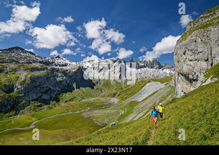 Mann und Frau Wandern mit Blick auf Tschingelhörner und unteren Segnesboden, tektonische Arena Sardona, Glarner Hauptschub, UNESCO-Weltnaturerbe G Stockfoto