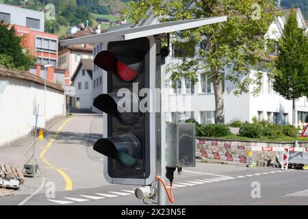 Tragbare Ampel mit Solarpaneelen auf der Straße, die den Verkehr während der Bauarbeiten in Schwyz, Schweiz, lenken. Stockfoto