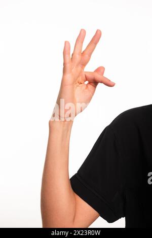 Nahaufnahme eines weiblichen Arms und einer Hand, die den Buchstaben F in brasilianischer Gebärdensprache für Gehörlose, Libras, herstellt. Salvador, Bahia. Stockfoto