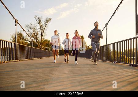 Glückliche Familie Mit Zwei Kindern Beim Joggen Im City Park Bei Sonnenuntergang Stockfoto