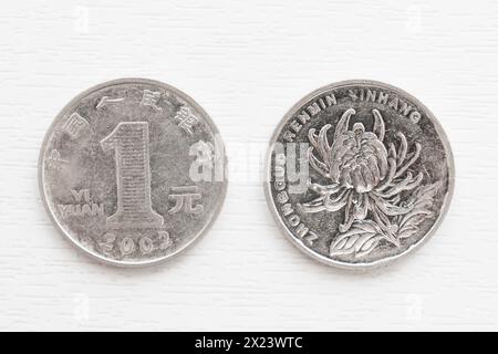 Zwei 1-Metall-Yuan-Münzen auf weißem Hintergrund. Yuan-Münzen mit verschiedenen Seiten. Stockfoto