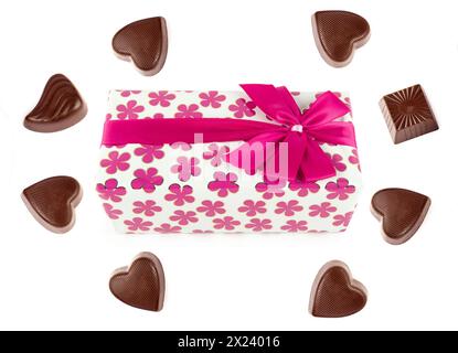 Schokoladenbonbons und eine Schachtel Schokolade in Geschenkverpackung isoliert auf weißem Hintergrund. Es ist freier Platz für Text vorhanden. Collage. Stockfoto