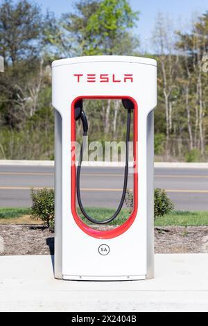 Nahaufnahme einer weiß-roten Tesla-Ladestation auf einem Parkplatz ohne Fahrzeuge. Stockfoto