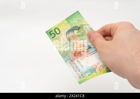 Mann mit 50 CHF Schweizer Franken Banknotenwährung isoliert auf weißem Hintergrund Stockfoto