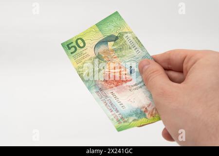 Mann mit 50 CHF Schweizer Franken Banknotenwährung isoliert auf weißem Hintergrund Stockfoto