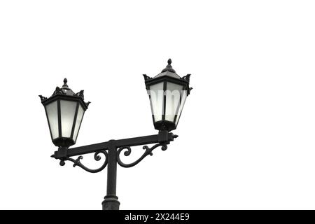 Straßenleuchte mit zwei Laternen, die die Nacht vor einem weißen Hintergrund beleuchten. Stockfoto