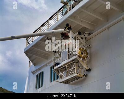 Philipsburg, St. Maarten – 24. Januar 2024: Ein Arbeiter an einem Hebebühne oder einem Kirschpflücker arbeitet neben einer Wartungsplattform, um eine Überkopflackierung durchzuführen Stockfoto