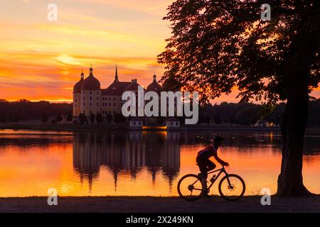 Moritzburg das Barocke Jagdschloss Moritzburg liegt auf einer Insel im Schlossteich. Radfahrer am Abend. Moritzburg Sachsen Deutschland *** Moritzburg das barocke Jagdschloss Moritzburg liegt auf einer Insel im Burgteich Radfahrer am Abend Moritzburg Sachsen Deutschland Stockfoto