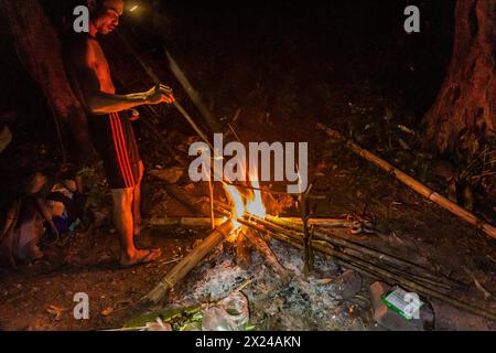 NAM HA, LAOS - 15. NOVEMBER 2019: Ortskundiger Reiseleiter bereitet das Abendessen im Wald des Nam Ha National Protected Area, Laos vor Stockfoto