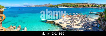 Freizeitplattform unter kristallklarem Wasser mit einer Insel im Hintergrund des paradiesischen Strandes von Ksamil-Albanien Stockfoto