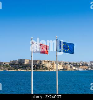 Die maltesischen und europäischen Flaggen winken vor dem Meer Stockfoto