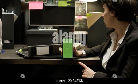 Kriminologen verwenden Greenscreen-Displays und untersuchen kriminelle Aktivitäten, um den Täter mit Beweisen zu fangen. Rechtsexperten arbeiten mit Chromakey-Vorlagen und Copyspace, Detektivarbeit. Stockfoto