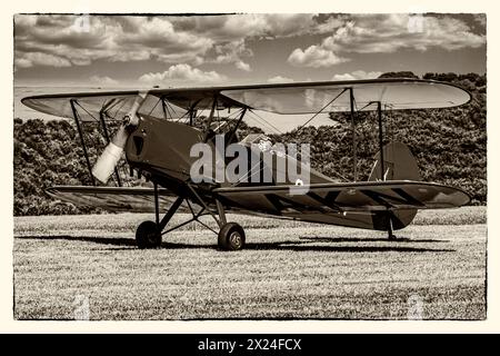 Ein helles rot 1930er Jahre de Havilland Tiger Moth auf der Graspiste Stockfoto