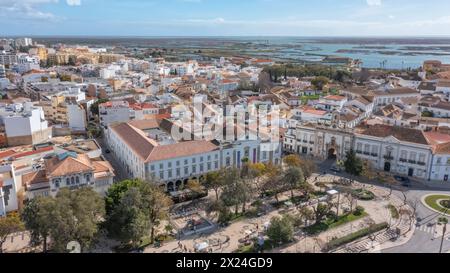 Traditionelle portugiesische Stadt Faro mit alter Architektur, gefilmt von Drohnen. Arco de Villa und largo de se. Ria formosa im Hintergrund. Stockfoto