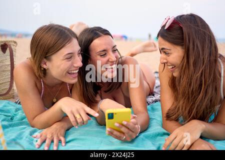 Porträtgruppe junger Z-kaukasischer Frauen, die auf das Handy zeigen und das Handy benutzen Stockfoto