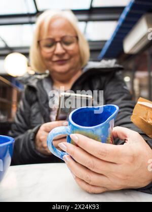 Die Seniorin fotografiert ihre handgemachten Geschenke Stockfoto