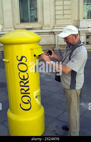 Sevilla, Spanien, España, Spanien; man legt einen Brief in den Briefkasten; Mann legt einen Brief in den Briefkasten; El hombre Pone una carta en el buzón. Stockfoto