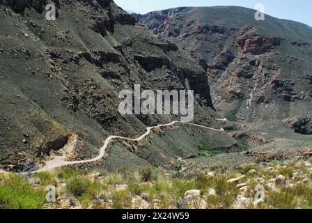 Bei einem Roadtrip durch die UNESCO-Region der Swartberg-Berge in Südafrika fahren Sie auf einer unbefestigten, schmalen Straße über den Pass. Stockfoto