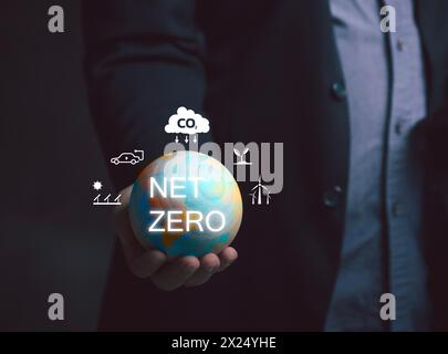 Netto-Null-Emission – Konzept der CO2-Neutralität. Ein Mann hält eine Globus-Ikone und hat eine Ikone, die ungefähr um die Netto-Null geht. Natur Сonservation, Ökologie, Soziale Angelegenheiten Stockfoto