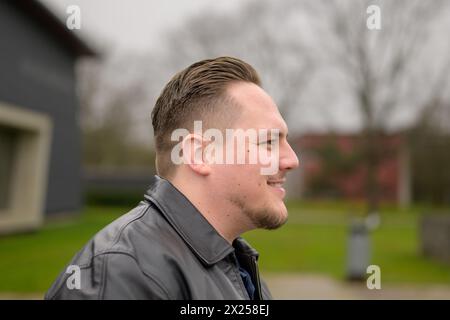 Seitenansicht eines jungen attraktiven Mannes in seinen Zwanzigern, der freundlich zur Seite aussieht Stockfoto