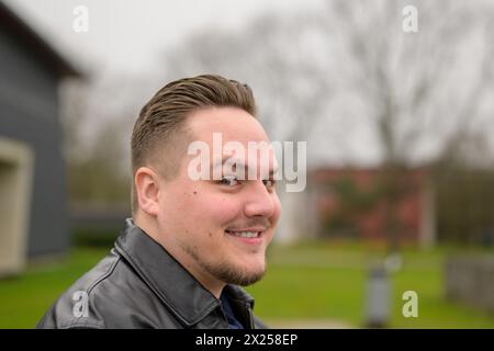 Nahaufnahme eines jungen attraktiven Mannes in seinen Zwanzigern, der seine Augenbraue hochhebt und freundlich in die Kamera blickt Stockfoto
