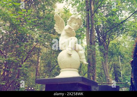 Engel im Friedhofsdenkmal am Grab einer Kinderskulptur in Form eines Engels. Stockfoto