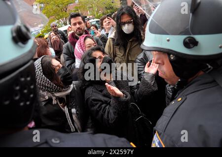 Pro-palästinensische Demonstranten singen während einer Kundgebung vor der Columbia University Slogans in der Nähe der Beamten des New York City Police Department. Pro-palästinensische Demonstranten versammelten sich innerhalb und außerhalb der Columbia University in Manhattan, New York City, und verurteilten die Militäroperationen der israelischen Streitkräfte in Gaza. Seit Mittwoch haben Studenten und pro-palästinensische Aktivisten innerhalb der Universität einen Sit-in-Protest auf dem Rasen abgehalten und ein Lager gebildet. Das New York City Police Department verhaftete am Donnerstag mehr als 100 Aktivisten aus dem Campus. Seit Beginn des Krieges am 7. Oktober 2023 Stockfoto