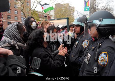 Pro-palästinensische Demonstranten singen während einer Kundgebung vor der Columbia University Slogans in der Nähe der Beamten des New York City Police Department. Pro-palästinensische Demonstranten versammelten sich innerhalb und außerhalb der Columbia University in Manhattan, New York City, und verurteilten die Militäroperationen der israelischen Streitkräfte in Gaza. Seit Mittwoch haben Studenten und pro-palästinensische Aktivisten innerhalb der Universität einen Sit-in-Protest auf dem Rasen abgehalten und ein Lager gebildet. Das New York City Police Department verhaftete am Donnerstag mehr als 100 Aktivisten aus dem Campus. Seit Beginn des Krieges am 7. Oktober 2023 Stockfoto